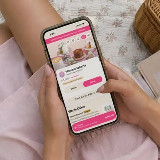 Ordering a Momma Jakarta cake on a phone during a picnic
